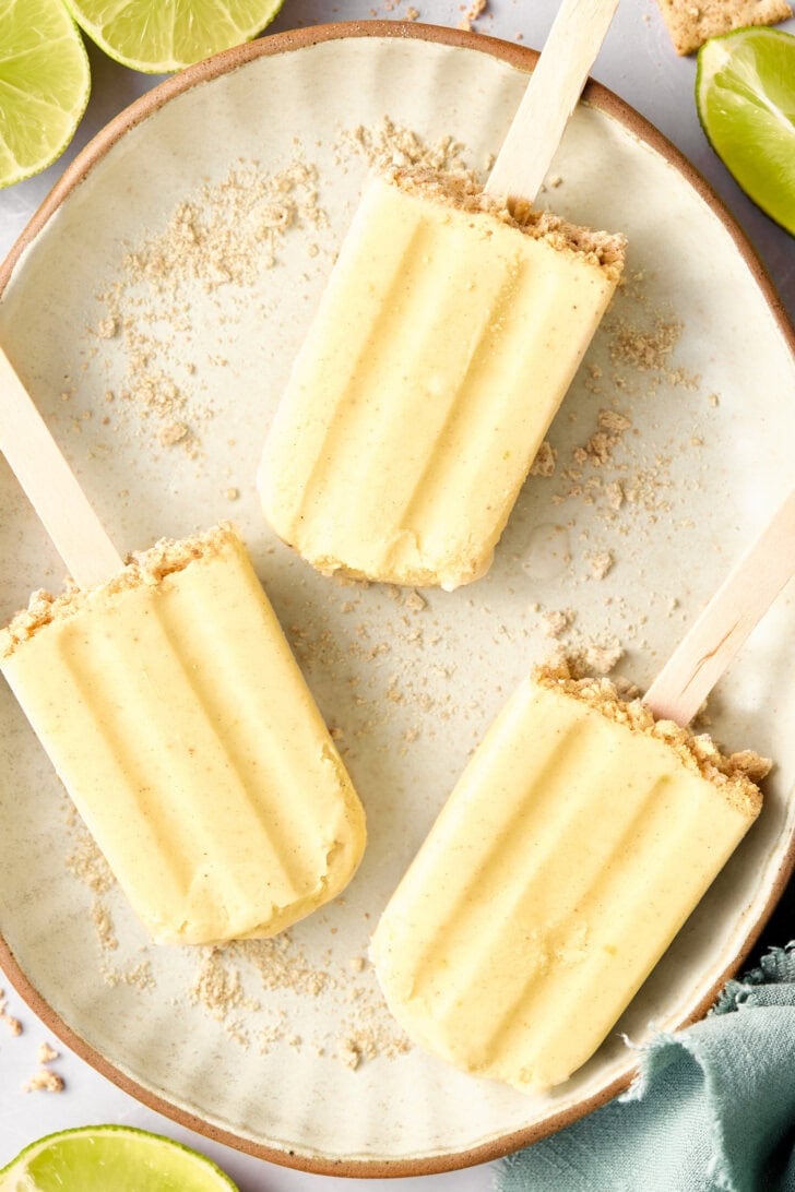 5-Ingredient Key Lime Pudding Pops - lime popsicles on a plate with graham cracker crust garnish
