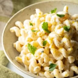 Large bowl of Boursin cheese pasta garnished with chopped parsley.