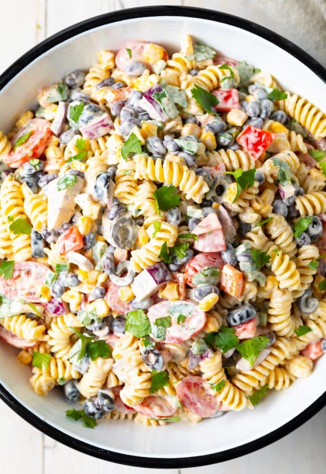 A top down shot of Creamy Southwest Pasta Salad in a white serving bowl.