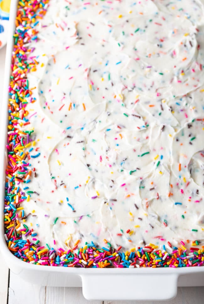 Funfetti frosting spread over cake.