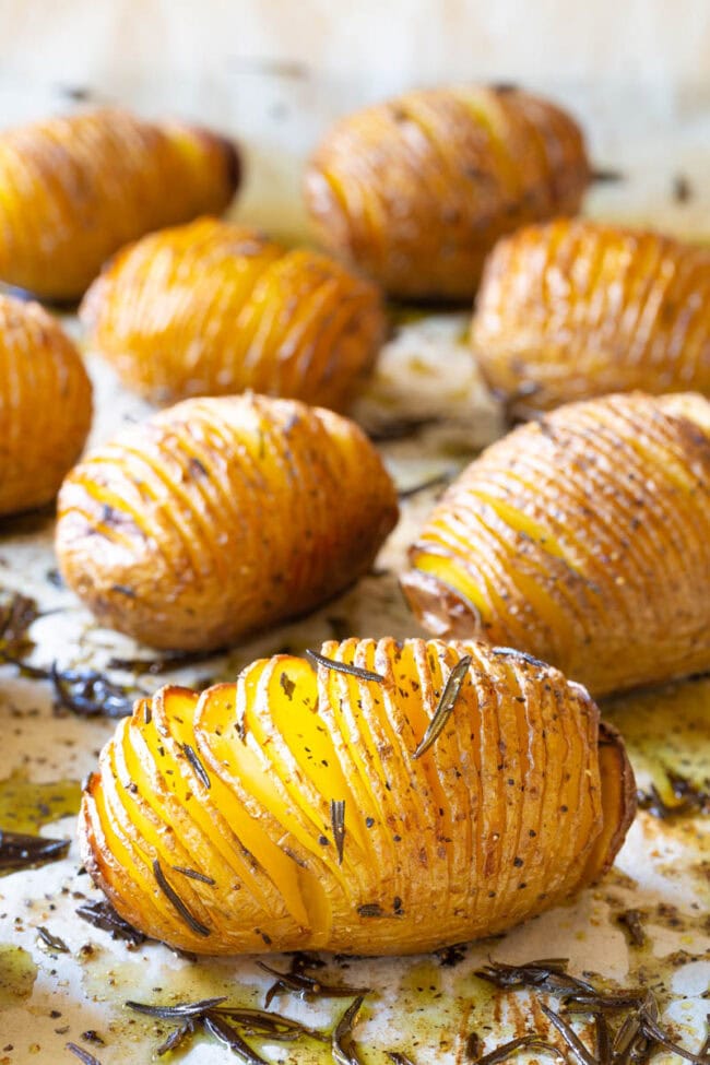 Crispy Hasselback Potatoes Recipe with Rosemary and Garlic on a baking sheet. 