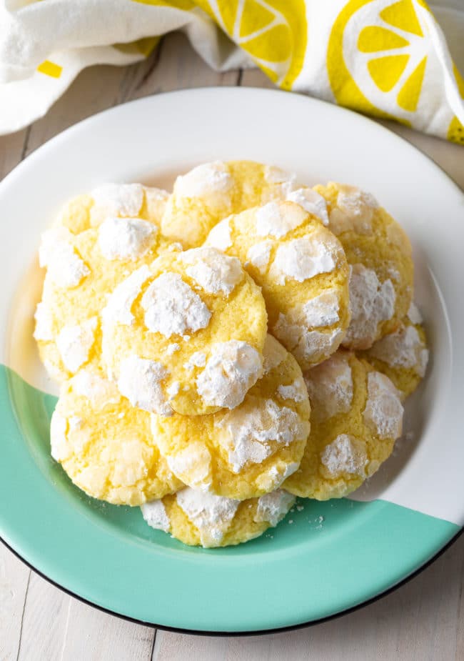 Overhead view of a plate full of stacked lemon crinkle cookies. 