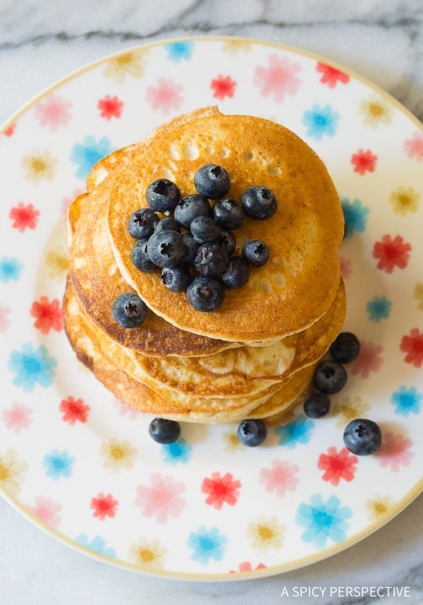Top down view of stacked low carb pancakes topped with blueberries. 