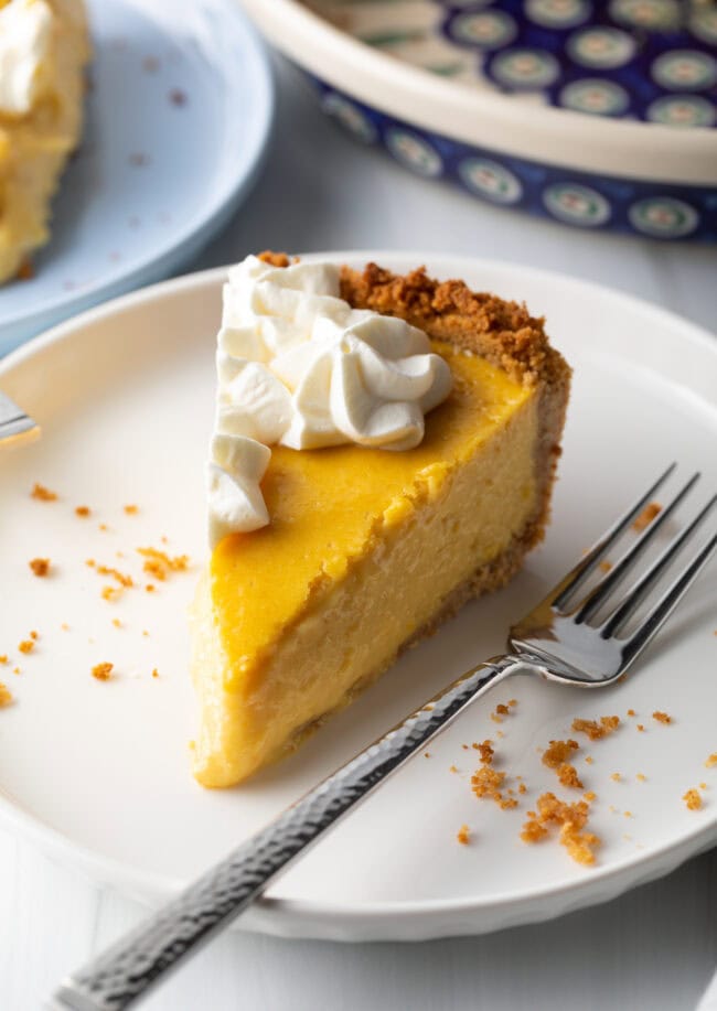 Slices of mango tart on a white plate, metal fork to the side.