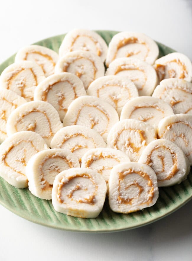 Potato Peanut Butter Candy - Green plate filled with round peanut butter potato candy slices.