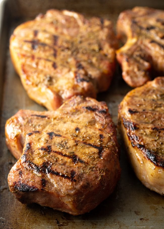 Close view Traeger smoked pork chops on a baking sheet.