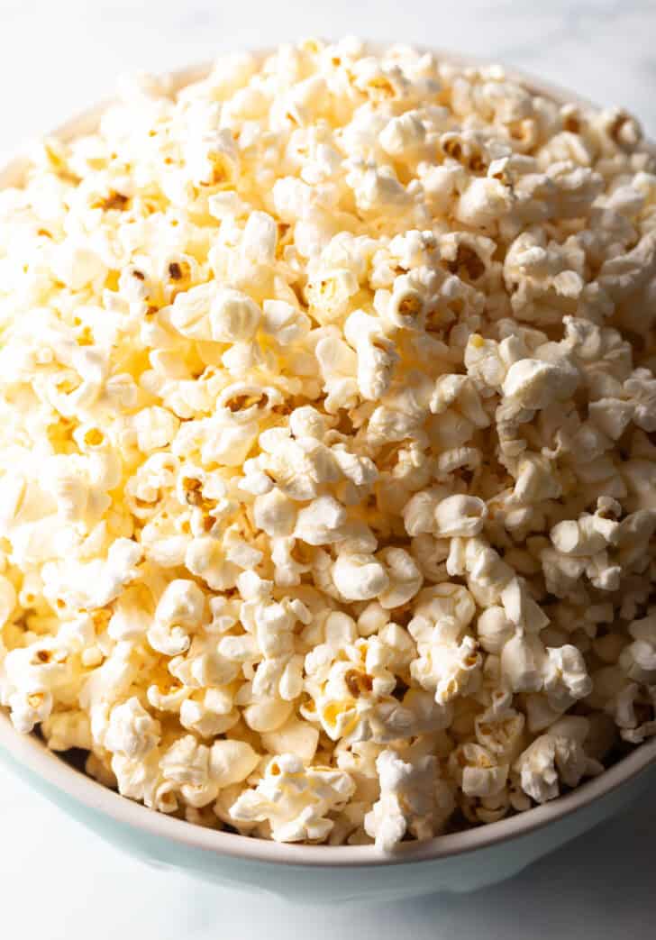 Top down view buttery ghee popcorn in a blue bowl.